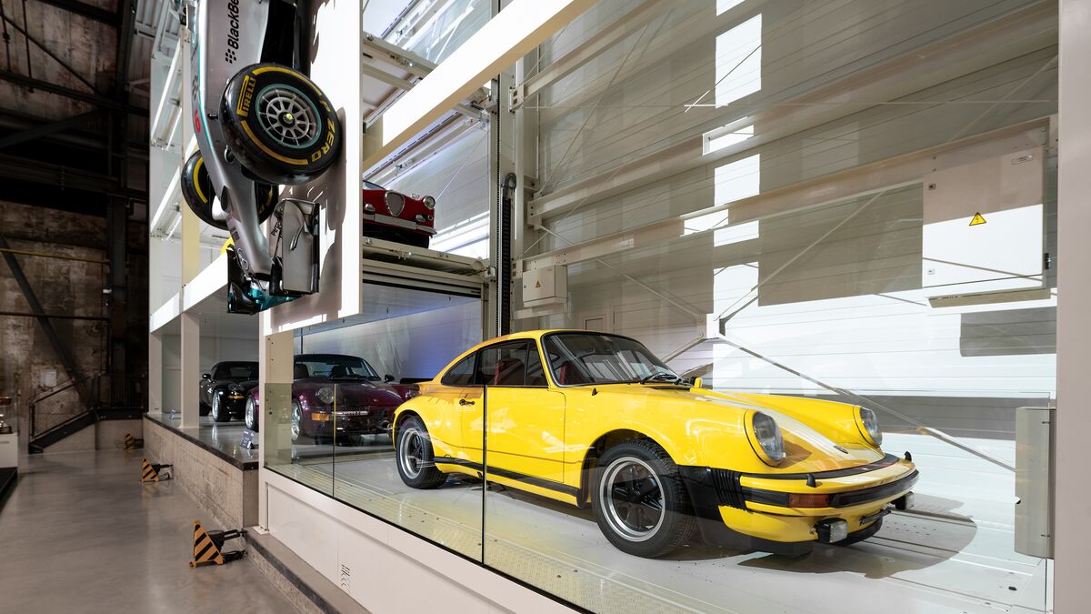 A yellow classic car parked in a parking system at a museum